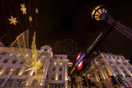 Photo for London, UK - Nov 20 2023: Looking up at buildings on Piccadilly Circus and Regent Street St James's. With Christmas lights and Piccadilly Circus underground station entrance. - Royalty Free Image
