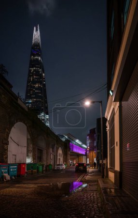 Photo for Southwark, London, UK: Holyrood Street alongside the London Bridge to Greenwich Railway Viaduct in the London borough of Southwark with view of the Shard skyscraper. - Royalty Free Image