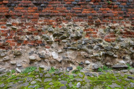 London, UK: Detail of the ancient city wall of London. This is a medieval wall with the Roman fort wall at its base and topped with a brick parapet added in 1477.