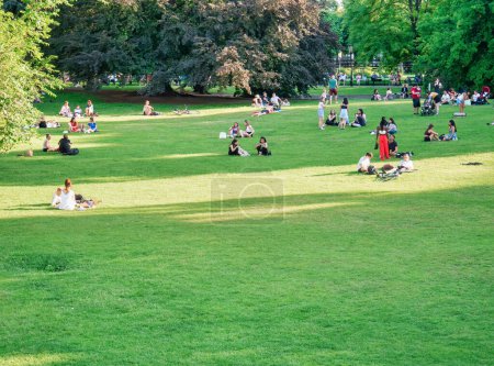 Photo for Vienna, Austria - June 2022: People, tourists and locals relaxing and having fun on the green grass in Burggarten park in Vienna. - Royalty Free Image