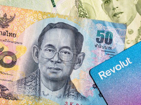 Foto de Macro detail with a 50 Thai Baht banknote and a revolut debit or credit card. The baht is the official currency of Thailand - Imagen libre de derechos