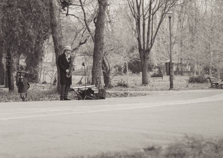 Téléchargez les photos : Bucarest, Roumanie - Avril 2023 : Homme musicien de rue jouant au saxophone dans le parc King Mihai I (Herestrau), à Bucarest. - en image libre de droit