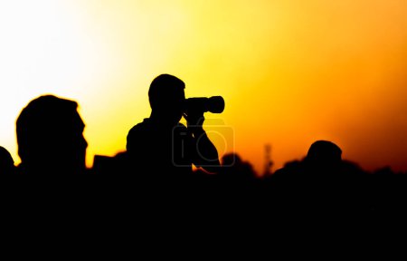 Foto de Una silueta de un fotógrafo con una cámara al atardecer. - Imagen libre de derechos