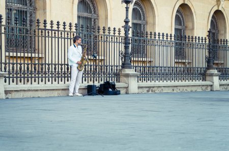 Téléchargez les photos : Bucarest, Roumanie - 17 août 2023 : Musicien de rue homme jouant au saxophone dans le centre de Bucarest sur la rue Victory (Calea Victoriei). - en image libre de droit