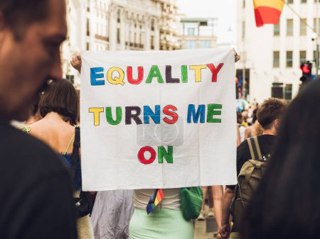 Foto de Mucha gente que asiste al desfile del Orgullo LGBTQ y muestra una pancarta con las palabras Igualdad me enciende - Imagen libre de derechos