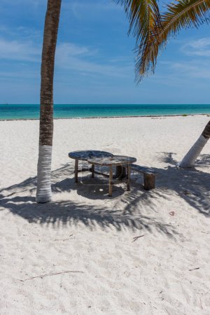 Foto de Pequeña mesa de picnic y sillas en el paraíso Playa remota cabo catoche con agua turquesa en holbox mexico. - Imagen libre de derechos