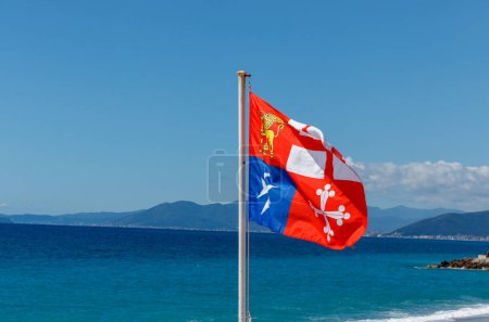 bandera de Marina Italiana Marina Militare agains blue sky with ocean on horizon.