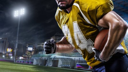 Téléchargez les photos : Gros plan joueur de football américain dans l'action sur la grande arène - en image libre de droit