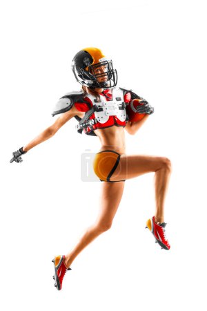 Téléchargez les photos : Portrait d'une jolie joueuse de football américaine brune en uniforme et T-shirt en jersey posant avec casque isolé sur fond blanc - en image libre de droit