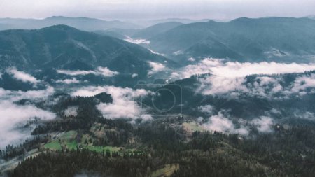 Foto de Paisaje con montañas, nubes bajas y bosque al amanecer descargar foto - Imagen libre de derechos