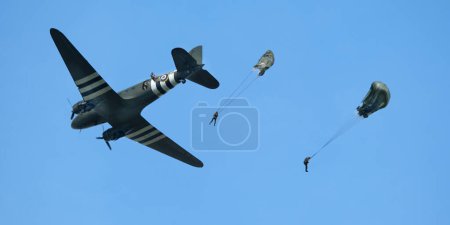 Photo for Victory Show. Leicester, UK, September. World war two living history show and airshow. The Douglas C-47 Skytrain or Dakota is a military transport aircraft developed from the civilian Douglas DC-3 airliner. Parachute troops dropping. - Royalty Free Image