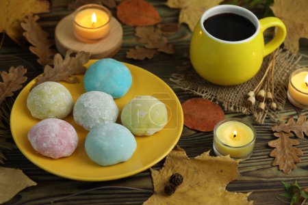 Photo for Colorful japanese sweets daifuku or mochi. Sweets close up on the plate with autumn leaves background and candles and coffee - Royalty Free Image