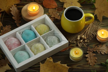 Photo for Colorful japanese sweets daifuku or mochi. Sweets close up on the plate with autumn leaves background and candles and coffee - Royalty Free Image