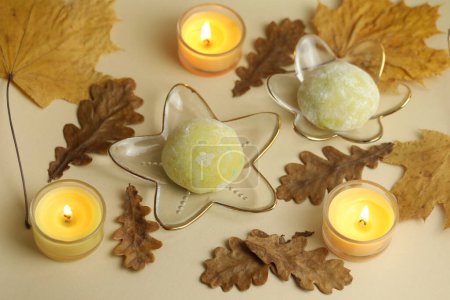 Photo for Colorful japanese sweets daifuku or mochi. Sweets close up on the plate with autumn leaves background and candles - Royalty Free Image