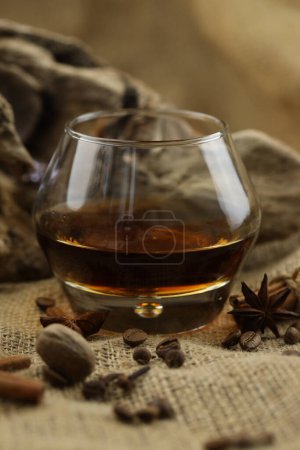 Photo for Glass of cognac with spice. Cloth background with copy space - Royalty Free Image