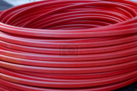 Foto de Twisted rubber red hose coiled. Household goods. - Imagen libre de derechos