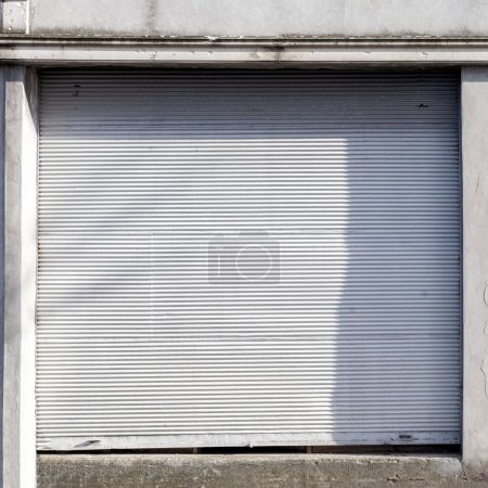 Foto de Puerta automática de persiana enrollable del almacén de almacenamiento. Almacenamiento o escaparate para el fondo metálico de la puerta - Imagen libre de derechos