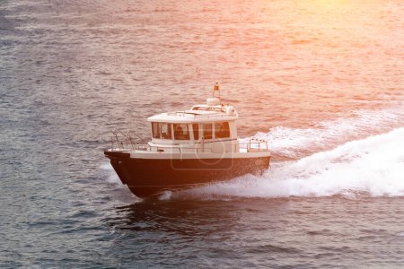 Téléchargez les photos : Petit bateau à moteur de pêche se déplaçant rapidement en pleine mer - en image libre de droit