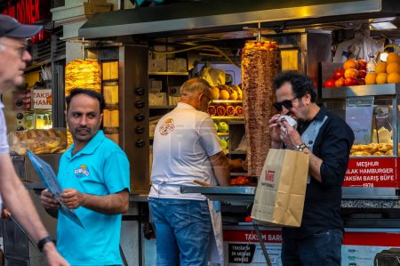 Photo for ISTANBUL TURKEY June 20 2023: Old man prepairing doner on the street. Taxim Istiklal street food - Royalty Free Image