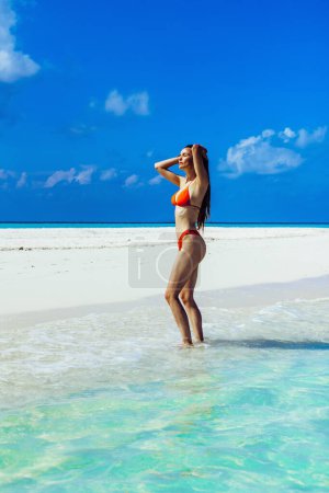 Téléchargez les photos : Belle fille en bikini sexy sur la plage. Beau corps féminin en forme. Voyage vacances. Fond marin - en image libre de droit