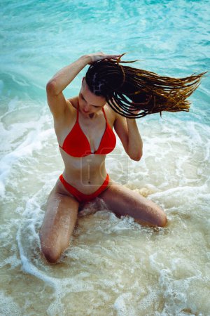 Foto de Hermosa mujer dreadlocks en bikini en la playa de arena paraíso tropical. Viajes de verano - Imagen libre de derechos