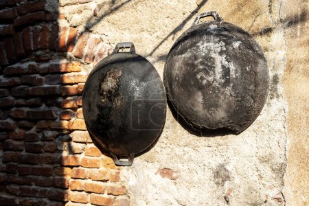 Photo for Old ancient dishes on cracked wall. Rusty cauldrons - Royalty Free Image