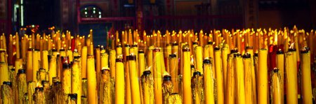 Téléchargez les photos : Bougies allumées qui brûlent dans le noir. Prières cire bougies dans le temple bhoutdiste - en image libre de droit