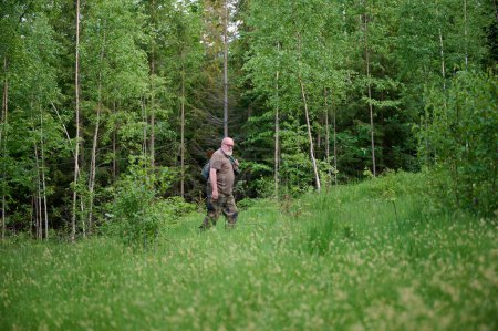 Foto de El cazador mayor camina por el bosque. - Imagen libre de derechos