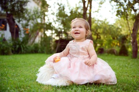 Photo for Adorable girl on the grass in the garden. Close up portrait. Happy little girl in summer scenery. Sweet small kid outdoors. - Royalty Free Image