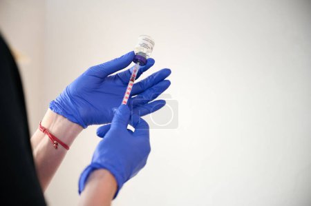 Photo for Close up view hands holding syringe with botox. Cosmetologist injects substance in patient modifying face to make non-surgical correction. Filler injections. Aesthetic corrective treatments concept. - Royalty Free Image