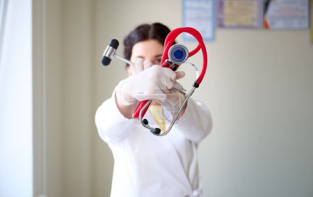 Foto de Retrato de una joven neuróloga con martillo y estetoscopio en las manos del médico - Imagen libre de derechos