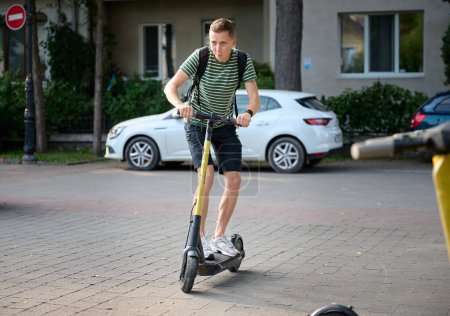 Foto de Joven montando un scooter eléctrico en el parque
. - Imagen libre de derechos