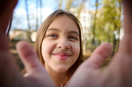 Téléchargez les photos : Portrait de mignonne jeune fille souriante dans le parc d'automne par temps ensoleillé et lumineux. Gros plan. - en image libre de droit