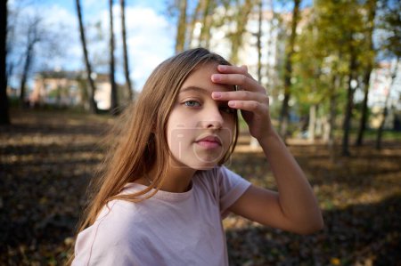 Téléchargez les photos : Portrait de jeune fille mignonne dans le parc d'automne par une journée ensoleillée et lumineuse. Gros plan. - en image libre de droit