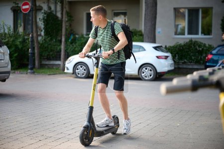 Photo for Young man riding an electric scooter in the park. - Royalty Free Image