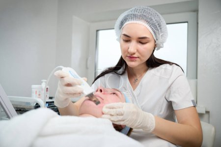 Foto de Vista de cerca de la limpieza de la piel y el procedimiento de peeling facial en el centro de belleza. Tratamiento de limpieza porosa profunda - Imagen libre de derechos