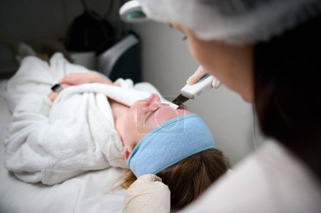 Foto de Vista de cerca de la limpieza de la piel y el procedimiento de peeling facial en el centro de belleza. Tratamiento de limpieza porosa profunda - Imagen libre de derechos
