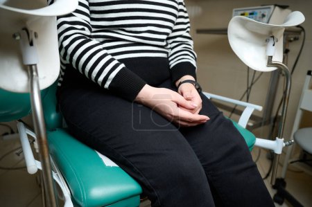 Photo for Crop view of pretty young woman sitting on gynecological chair and waiting for examination. Women's health. Prevention illness. Early detection of cancer. Examining and consulting patient in clinic. - Royalty Free Image