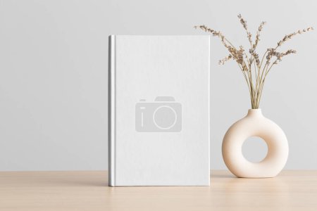 Photo for White book mockup with a lavender decoration on the wooden table. - Royalty Free Image