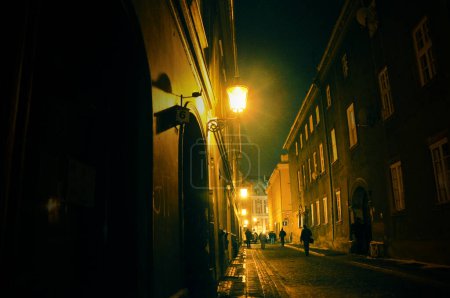 Paysage urbain nocturne de Poznan, ruelle avec maisons d'habitation éclairées par des lanternes