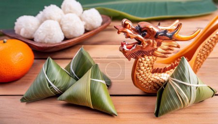 Dragon Boat Festival poster. Dragon Boat with zongzi and festive elements on lotus leaf.
