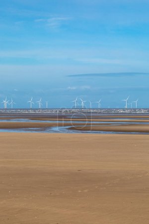 Téléchargez les photos : Une vue sur une plage de sable fin à marée basse avec un parc éolien off shore au loin, à Formby à Merseyside - en image libre de droit