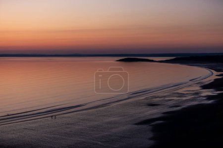 Ein idyllischer Blick über die Rhossili Bay auf der Gower Peninsula bei Sonnenuntergang