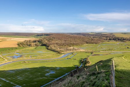 A view over the Cuckmere Valley in the South Downs, with a blue sky overhead