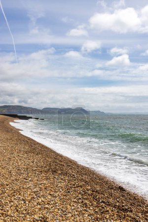 The pebble beach at Lyme Regis in Dorset, on a sunny April day