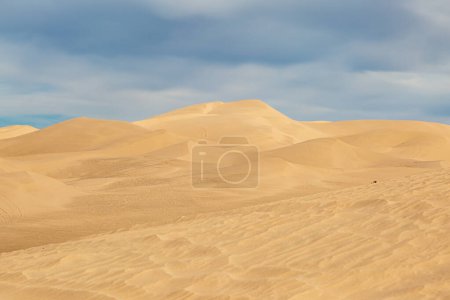 The Algodones Dunes in California, with sunshine and clouds overhead