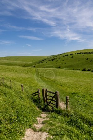 Photo for A rural South Downs landscape at Mount Caburn near Lewes, with a gate and footpath leading over a hillside - Royalty Free Image