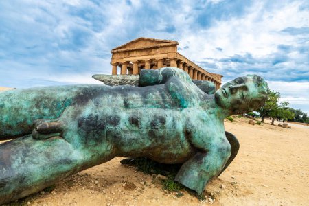 Foto de Templo de Concordia y la estatua de bronce de Ícaro en el Valle dei Templi o Valle de los Templos en Agrigento, Sicilia, Italia - Imagen libre de derechos