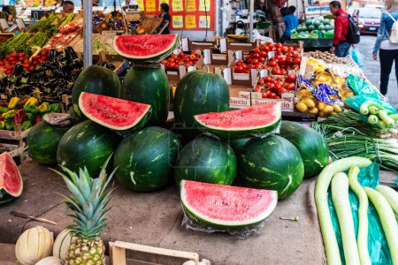 Foto de Palermo, Italia - 13 de mayo de 2023: Sandías en una tienda de frutas y verduras en Ballaro Market, mercado callejero de alimentos con gente alrededor en Palermo, Sicilia, Italia - Imagen libre de derechos