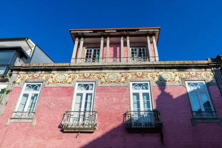 Foto de Fachada de un antiguo edificio rojo clásico decorado con azulejos en el casco antiguo de Braga, Portugal - Imagen libre de derechos